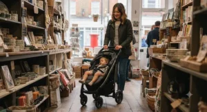 A stylish best lightweight pushchair being steered through a narrow high street shop.