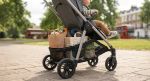 Spacious storage basket underneath a black forward-facing pushchair loaded with shopping bags