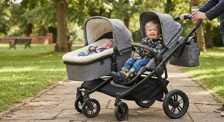 Side by side double buggy configured with a lie-flat newborn carrycot and a toddler seat
