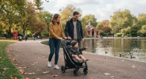Young parents walking through a British park using the best lightweight pushchair.