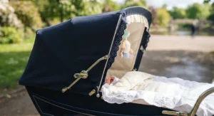 Close up of a classic pram for a newborn featuring a fully extended protective hood.