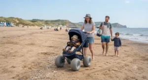 A family enjoying a seaside day out with their all-terrain beach stroller featuring large sand wheels