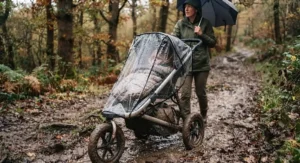 An off-road pushchair fitted with a transparent rain cover during a light British drizzle