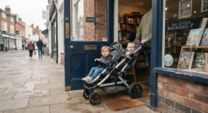 Slim compact double buggy easily passing through a standard shop doorway in a UK high street.