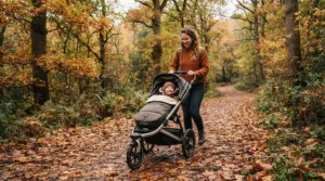 A family weekend walk through woodland paths featuring a pushchair for older child.