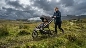 A rugged double pushchair under £300 tackling uneven rural terrain with three wheels and sturdy suspension