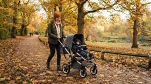 A durable pushchair £300 to £600 rolling smoothly over crisp fallen leaves on a suburban pavement.