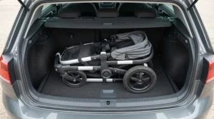Demonstrating the compact fold size of a pushchair for twins under £600 stored inside a family car boot.