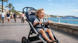 A forward-facing toddler enjoying the view from a pushchair with reversible seat under £600 near a seaside promenade.